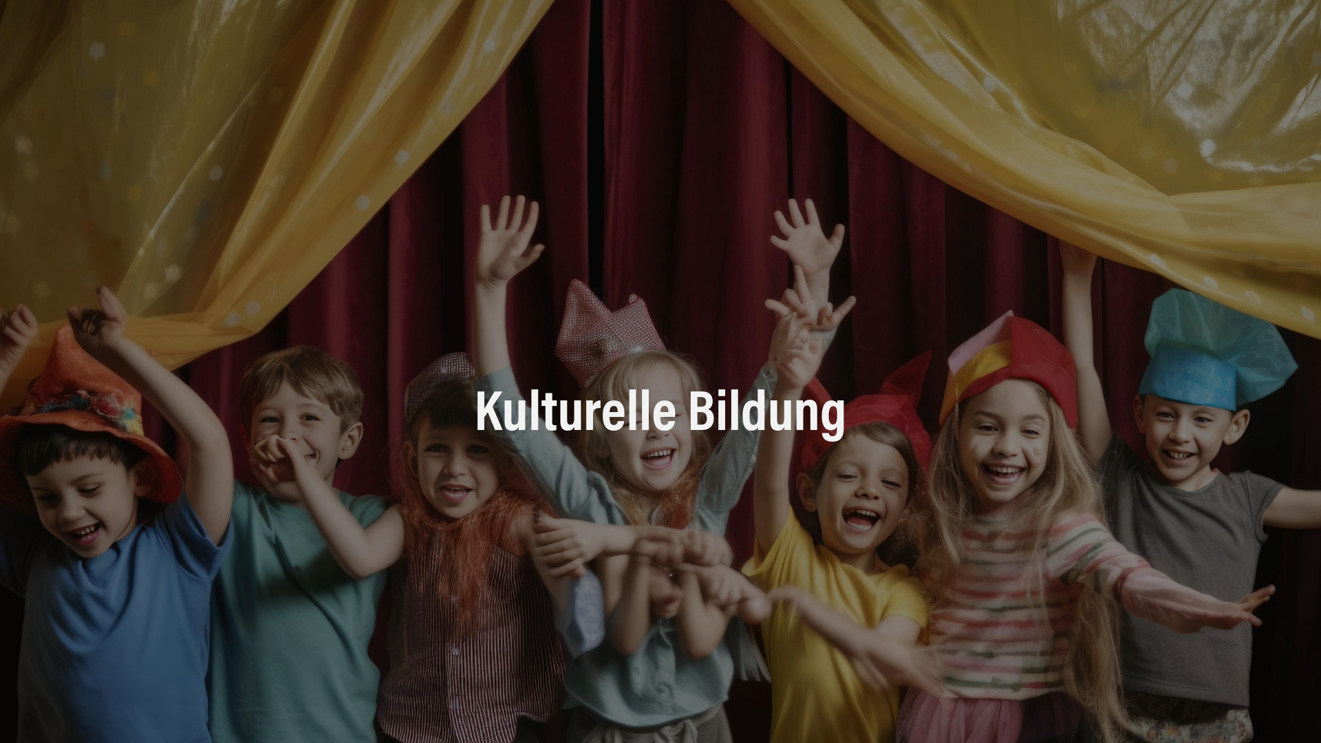 Eine Gruppe verkleideter Kinder steht jubelnd auf einer Bühne mit rotem Vorhang und gelben Stoffbahnen.