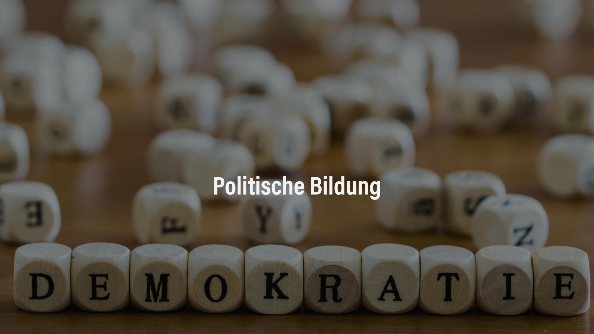 Politische Bildung Nahaufnahme von Holzbuchstabenwürfeln, die das Wort „Demokratie“ bilden.