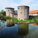 Im Wassergraben spiegeln sich drei von vier Türme der Burgruine Friedewald. 