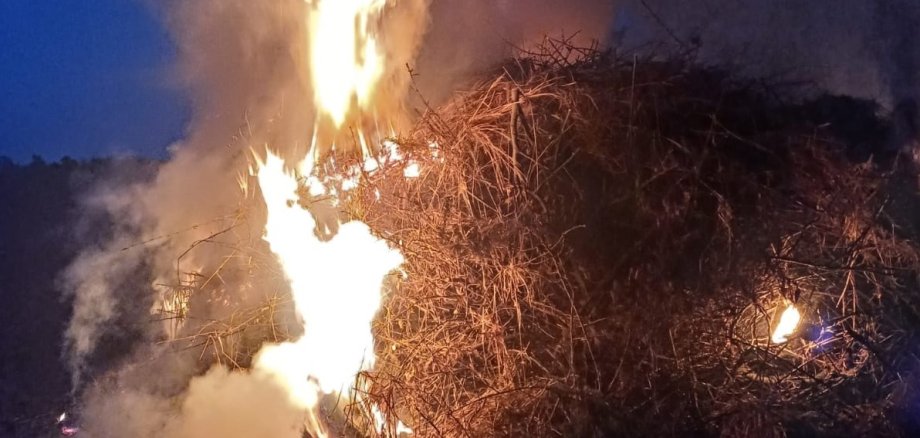 Ein Feuer brennt. Es ist dunkel und Abend.
