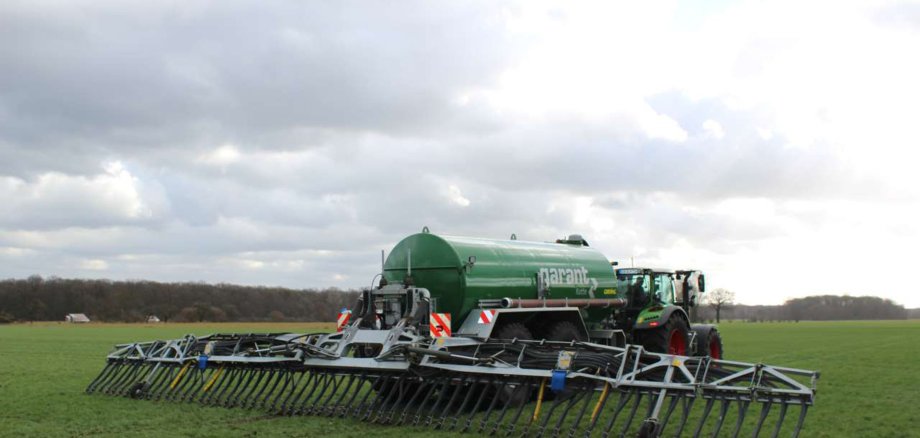 Ein Schleppschlauchverteiler fährt auf dem Feld.