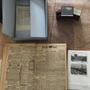 Links oben ein Karton, der halb geöffnet ist und worin alte Zeitungen liegen. Im Hintergrund liegt eine antike Karte, unten links eine historische Ausgabe des Kreisblatts von 1885. Rechts unten ein Fotoalbum mit schwarz-weiß Fotos vom Bahnhof Bebra und einem Tunnel. Oben in der Mitte liegt ein Dia, daneben steht Dorflinden.