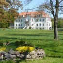 Das Rathaus der Gemeinde Hohenroda. Im Vordergrund sind eine grüne Wiese und angepflanzte Blumen zu sehen. Das Wetter ist schön.