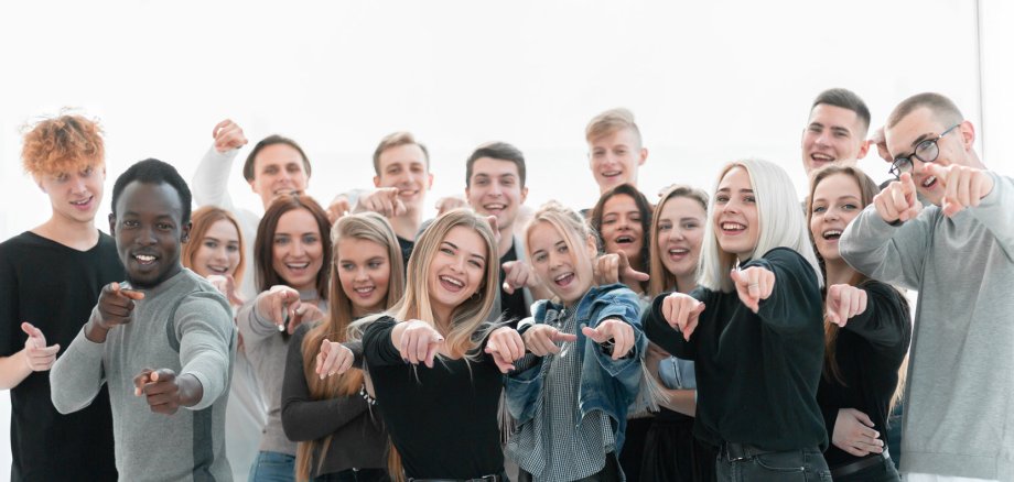 Gruppe selbstbewusster junger Leute, die auf dich zeigen. Weißer Hintergrund