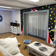 In einem rechteckigen Raum stehen ein  Sofa aus Paletten und ein paar Stühle. Im Vordergrund sieht man einen Tischkicker.