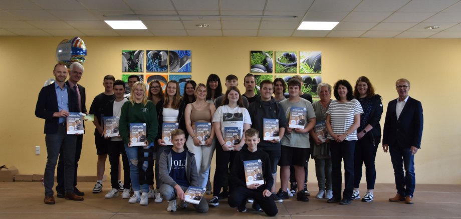 Eine Gruppe von Schülerinnen und Schülern steht in einer Gruppe. Sie halten eine Broschüre, das Ausbildungsnavi. Landrat Warnecke ist ebenfalls auf dem Foto zu sehen.