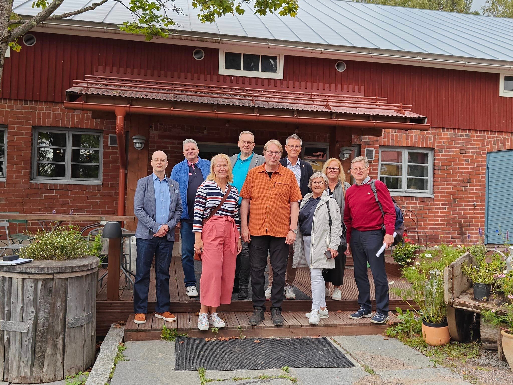 Eine Gruppe aus finnischen und deutschen Menschen steht vor dem Musterbauernhof von Familie Eerola in Hyvinkää, der finnischen Partnerregion des Landkreises Hersfeld-Rotenburg.