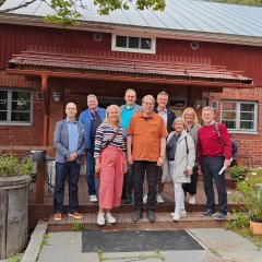 Eine Gruppe aus finnischen und deutschen Menschen steht vor dem Musterbauernhof von Familie Eerola in Hyvinkää, der finnischen Partnerregion des Landkreises Hersfeld-Rotenburg.