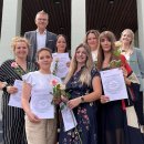 Gruppenbild auf der Treppe vor dem Hersfelder Landratsamt: Der Erste Kreisbeigeordnete Dirk Noll und Isabell Schmidt von der Fachberatung Kindertagespflege beglückwünschen (hinten rechts) sechs neue Tagesmütter im Landkreis Hersfeld-Rotenburg.  Die Tagesmütter zeigen ihre Teilnahmebescheinigung und geschenkte rosa Rose.