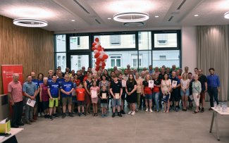 Viele Menschen, die Siegerinnen und Sieger des Stadtradelns 2023 im Landkreis Hersfeld-Rotenburg, stehen für ein Gruppenfoto im Kreistagssitzungssaal.