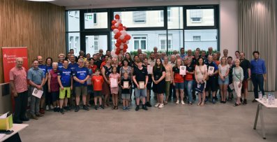 Viele Menschen, die Siegerinnen und Sieger des Stadtradelns 2023 im Landkreis Hersfeld-Rotenburg, stehen für ein Gruppenfoto im Kreistagssitzungssaal.