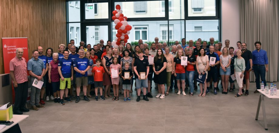 Viele Menschen, die Siegerinnen und Sieger des Stadtradelns 2023 im Landkreis Hersfeld-Rotenburg, stehen für ein Gruppenfoto im Kreistagssitzungssaal.