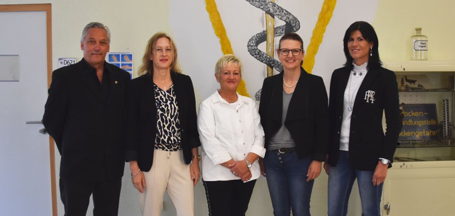 Vier Mitarbeiterinnen und ein Mitarbeiter der Betreuungsbehörde stehen im Gesundheitsamt der Kreisverwaltung.