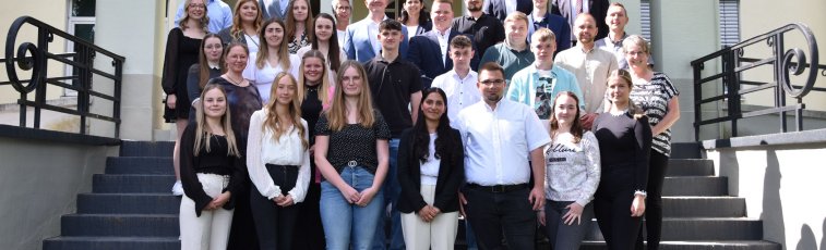 Viele Menschen stehen auf einer Treppe vor dem Landratsamt in Bad Hersfeld. Darunter sind neue Auszubildende, Studierende und Anwärterinnen sowie der Landrat und Erster Kreisbeigeordneter.