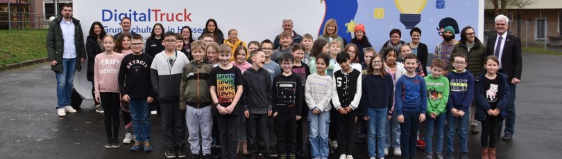 Schülerinnen und Schüler der Kreuzbergschule in Philippsthal stehen mit Vertretern aus Politik und Bildungssektor vor dem Digital-Truck des Landes Hessen.