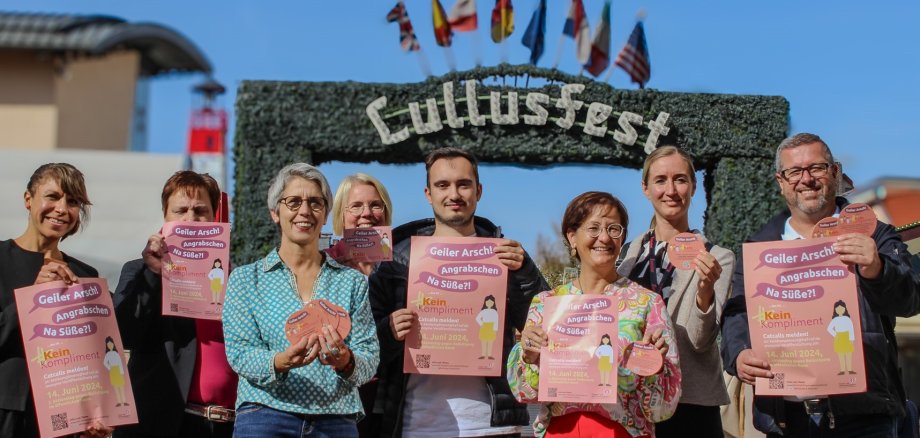 Eine Gruppe von Menschen hält Plakate vor dem Eingang zum Lullusfest hoch. Die Plakate machen auf Catcalling aufmerksam: Catcalling ist kein Kompliment.