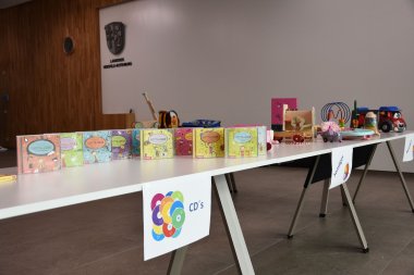 Die Spielzeuge sind auf Tischen verteilt. Schilder zeigen an, wo welche Spielzeuge liegen.