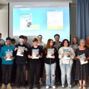 Gruppenfoto der Klasse Bo3 der Friedrich-Fröbel-Schule vor einer Leinwand mit Landrat Torsten Warnecke. Die Schülerinnen und Schüler halten das Ausbildungs-Navi in der Hand.