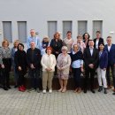 Einige Mitarbeitende der Kreisverwaltung stehen im Innenhof der Kreisverwaltung und lächeln in die Kamera.