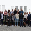 Ungefähr 20 Leute stehen im Innenhof des Landratsamtes. Sie lächeln in die Kamera. Rund um sie herum sieht man einige grüne Pflanzen.