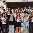 Viele Schülerinnen und Schüler und wenige Erwachsene stehen auf einer Treppe auf dem Schulhof vor der Modellschule Obersberg.