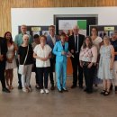 Rund 20 Personen stehen im Kreistagssitzungssaal der Kreisverwaltung. Sie lächeln und stehen in einer Gruppe.