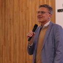 Ein Mann steht vor einer Holzwand im Kreistagssitzungssaal der Kreisverwaltung.