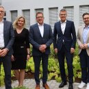 Fünf Menschen stehen im Innenhof des Landratsamtes und lächeln in die Kamera. Man sieht einige Pflanzen und im Hintergrund Fenster.