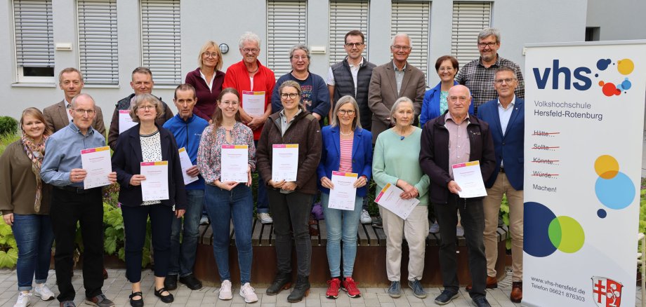 Die Teilnehmenden stehen mit ihren Zertifikaten im Innenhof der Kreisverwaltung. Sie freuen sich.