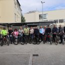 Mitarbeitende der Kreisverwaltung und Landrat Torsten Warnecke stehen vor der neuen Fahrradabstellanlage am Landratsamt. Jeweils neben ihnen stehen ihre Fahrräder. Sie freuen sich.