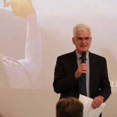 Ein Mann steht mit Mikrofon im Kreistagssitzungssaal des Landratsamtes.
