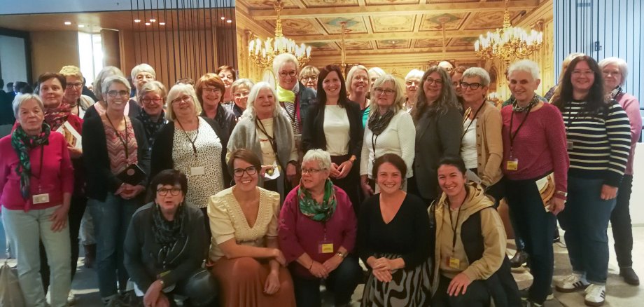 Eine Gruppe von etwa 30 Frauen, die an einer vom Frauenbüro des Landkreises Hersfeld-Rotenburg organisierten Fahrt in den Hessischen Landtag teilgenommen haben, steht gemeinsam mit vier Landtagsabgeordneten für ein Gruppenfoto.