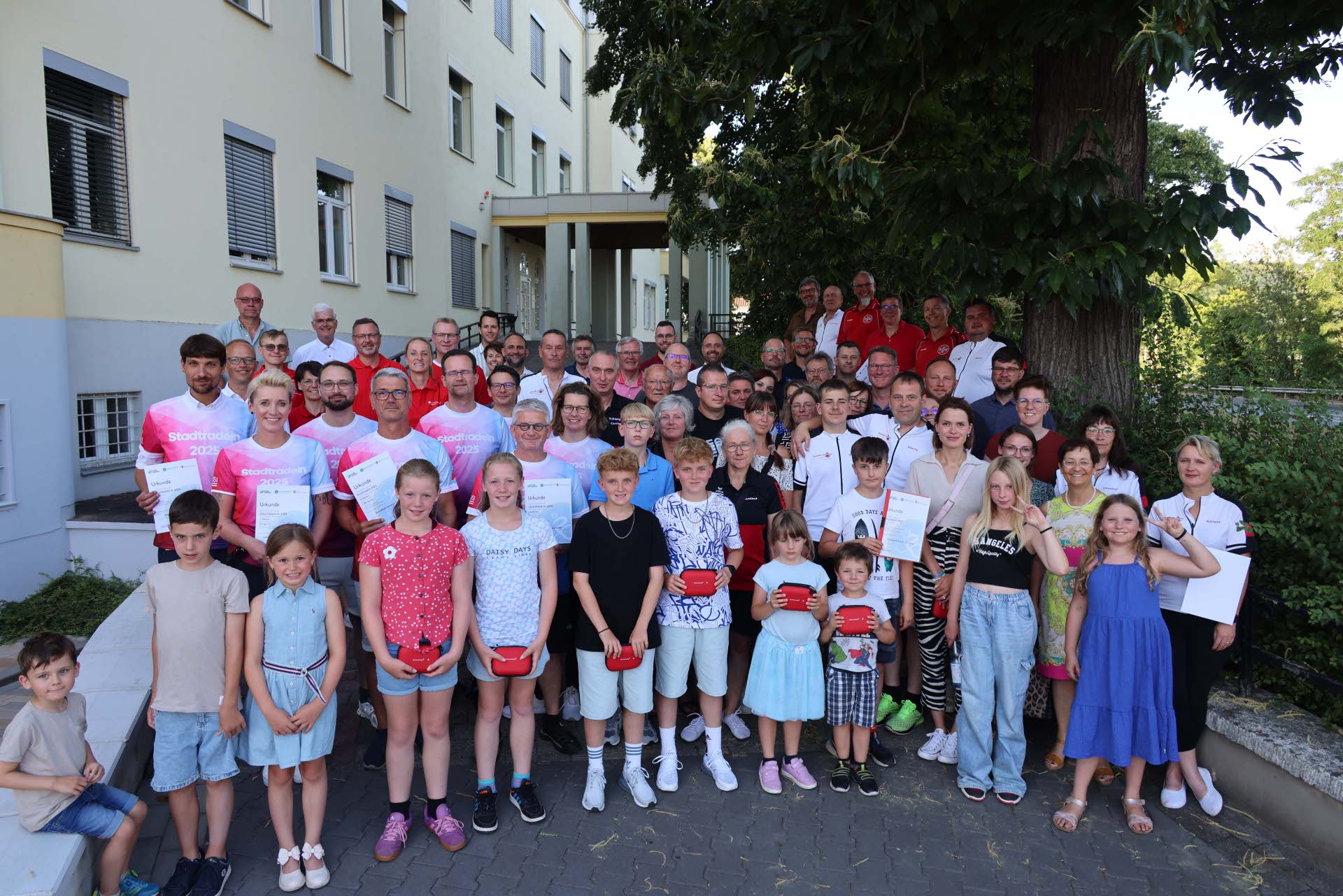 Große Gruppe aus Kindern und Erwachsenen bei der Siegerehrung des Stadtradelns vor dem Landratsamt Hersfeld-Rotenburg. Einige Personen halten Urkunden oder Preise in der Hand.