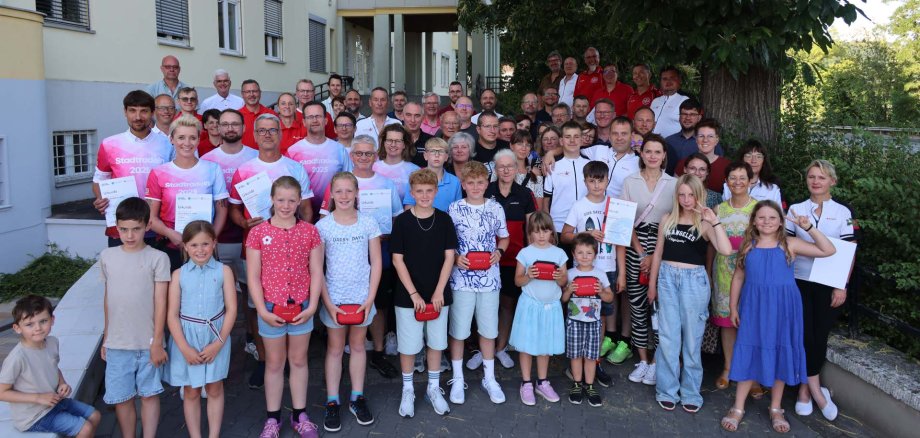 Große Gruppe aus Kindern und Erwachsenen bei der Siegerehrung des Stadtradelns vor dem Landratsamt Hersfeld-Rotenburg. Einige Personen halten Urkunden oder Preise in der Hand.