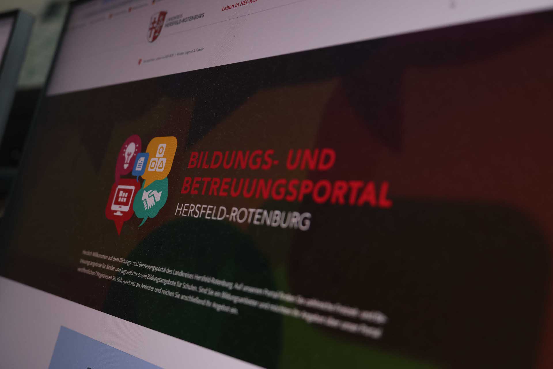 Ein Bildschirm zeigt das Bildungs- und Betreuungsportal des Landkreises Hersfeld-Rotenburg. Auf dem Display sind bunte Symbole zu Bildungsthemen und der Schriftzug „Bildungs- und Betreuungsportal Hersfeld-Rotenburg“ zu sehen.
