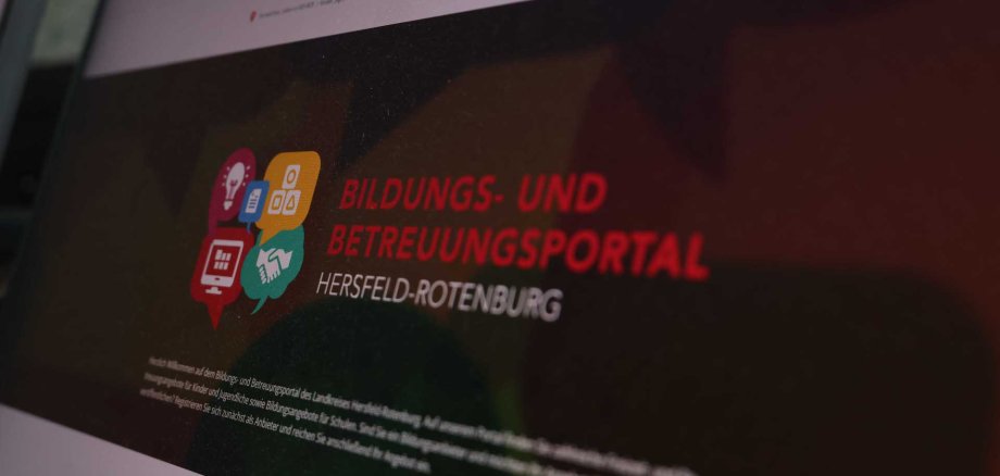 Ein Bildschirm zeigt das Bildungs- und Betreuungsportal des Landkreises Hersfeld-Rotenburg. Auf dem Display sind bunte Symbole zu Bildungsthemen und der Schriftzug „Bildungs- und Betreuungsportal Hersfeld-Rotenburg“ zu sehen.