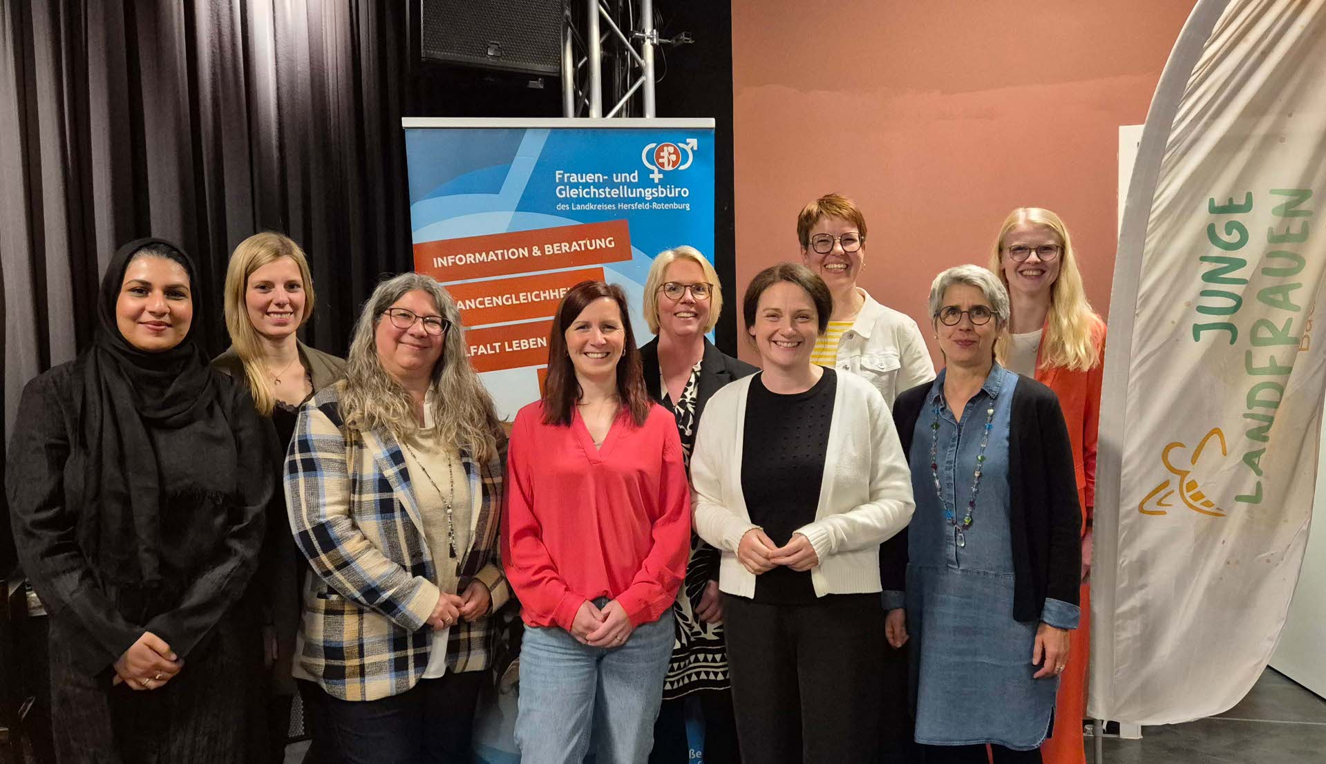 Zehn Frauen stehen lächelnd für ein Gruppenfoto nebeneinander. Im Hintergrund stehen Roll-Ups vom Frauen- und Gleichstellungsbüro und den Jungen Landfrauen. Die Atmosphäre wirkt freundlich und professionell.