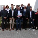 Eine Gruppe von 15 Personen steht im Innenhof eines Verwaltungsgebäudes, in der Mitte hält ein Mann ein Dokument mit dem Titel der OloV-Strategie. Es handelt sich um Vertreterinnen und Vertreter aus Kreisverwaltung, Wirtschaft, Schulen und Verbänden, die sich gemeinsam für die berufliche Orientierung von Jugendlichen im Landkreis Hersfeld-Rotenburg einsetzen.
