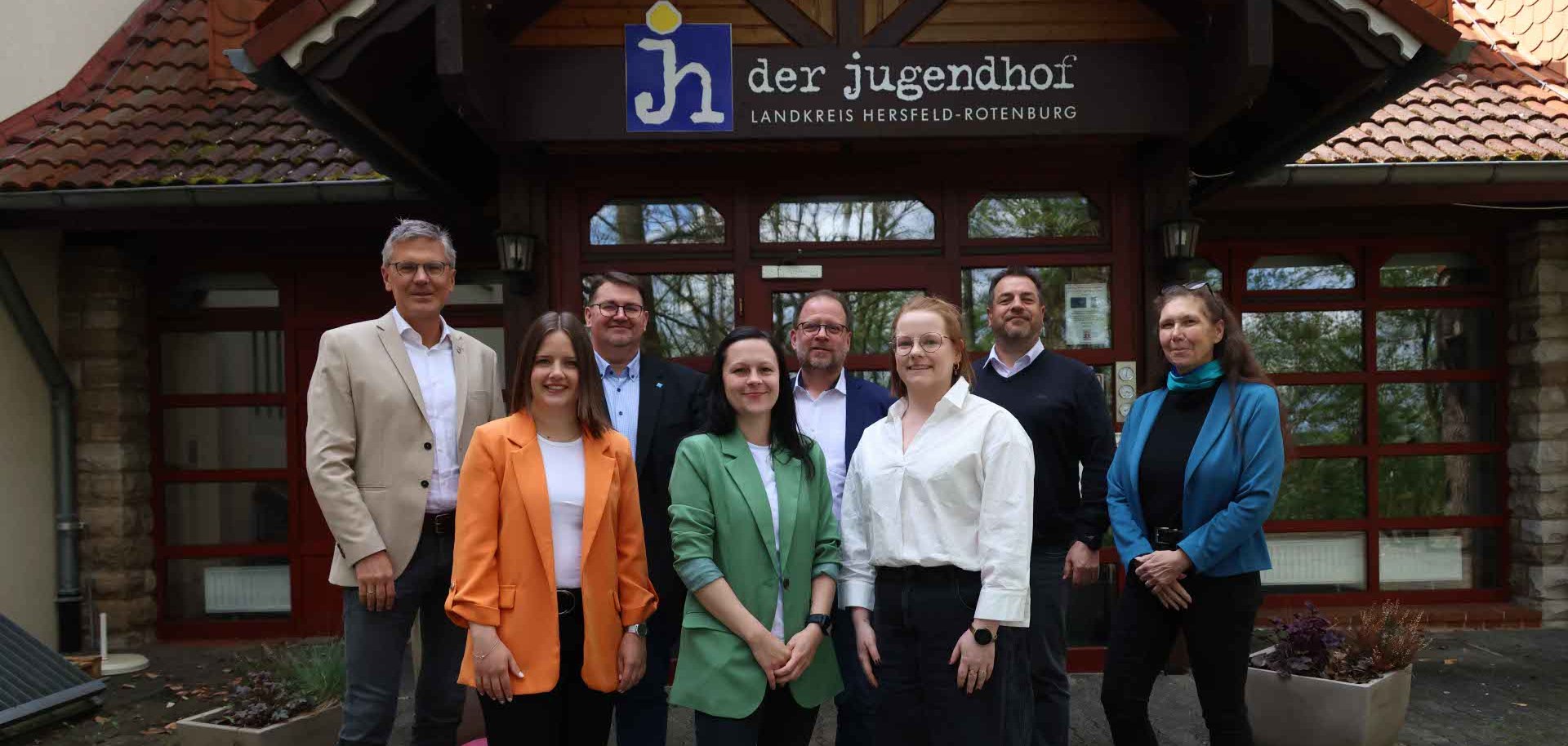 Mehrere Personen stehen vor dem Eingang des Rotenburger Jugendhofs. Sie schauen in die Kamera und sind gut gelaunt.