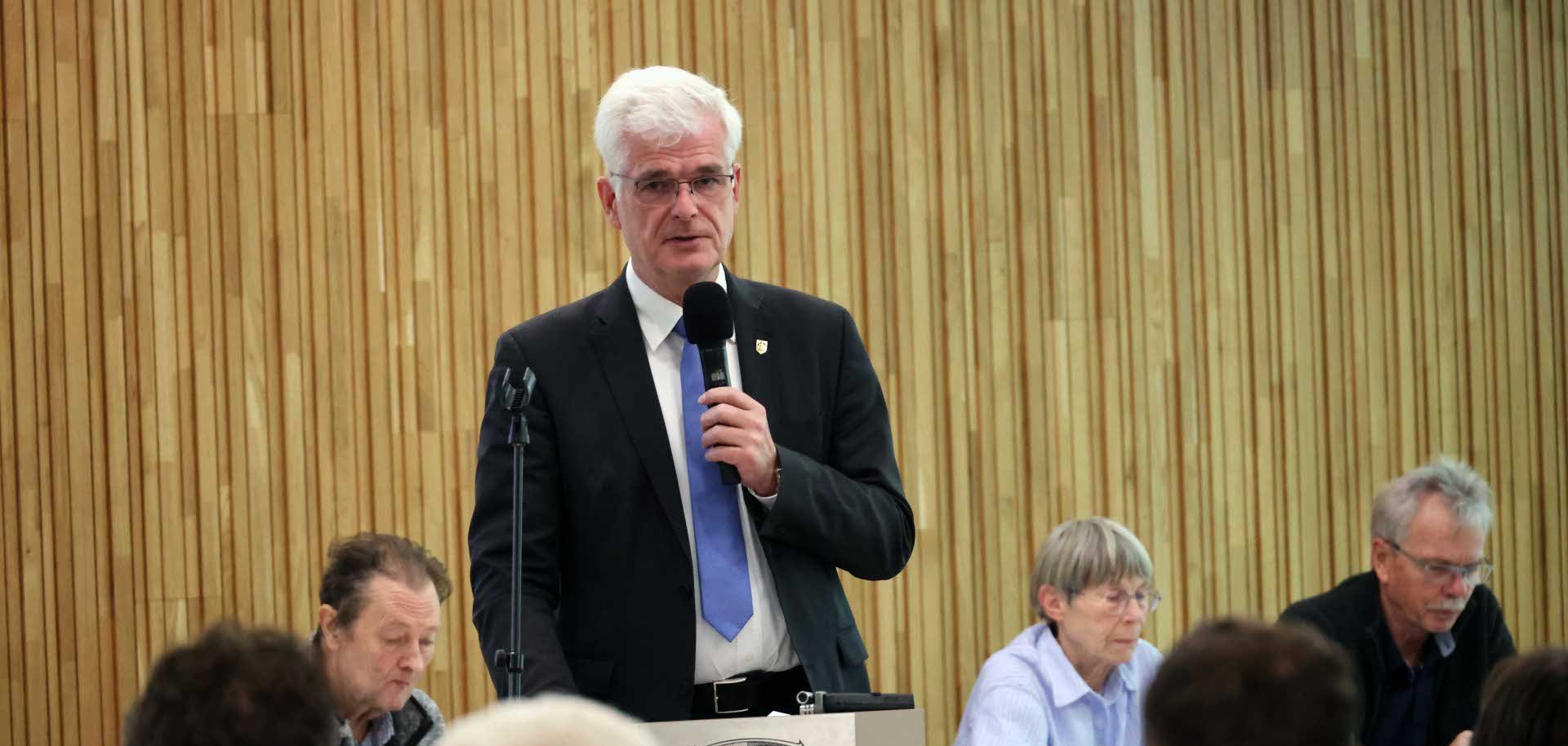 Ein Mann spricht in ein Mikrofon.