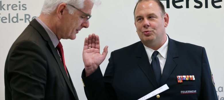 Vereidigung Patrick Kniest als stellvertretender Kreisbrandmeister Landrat Torsten Warnecke liest die Eidesformel vor, während Patrick Kniest in Feuerwehruniform zur Vereidigung die rechte Hand hebt.